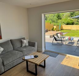 A living room with a sofa and coffee table at Y Bwthyn in Pembrey