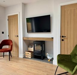 A living room with a television and chairs at Y Bwthyn in Pembrey