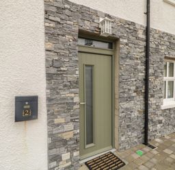 A front entrance with a door and stone wall at 2 Ard an Chuain Dunfanaghy