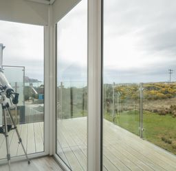 A conservatory with a telescope and views of hills at 2 Ard an Chuain Dunfanaghy