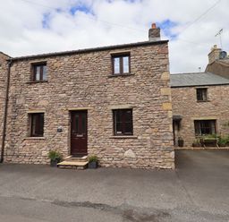 A stone house with windows and a front door at 4 Mellbecks Mews Kirkby Stephen