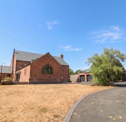 A house and garage with a driveway and tree at Hazeldene near Harvington