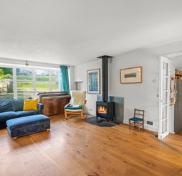 A living room with a sofa and stove at Chantry Studio in Kingsbridge