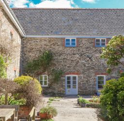 An outdoor area with stone building and garden features at Chantry Studio in Kingsbridge