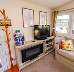 A living room with a sofa and television at Sunflower Retreat, Caravan 61