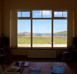 A living room with a guitar and a view of mountains and water at Welcome to the wild Atlantic way Mulroy Bay