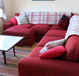 A living room with a red sofa and a coffee table at Welcome to the wild Atlantic way, Mulroy Bay