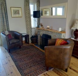 A living room with armchairs and a fireplace at Welcome to the wild Atlantic way Mulroy Bay