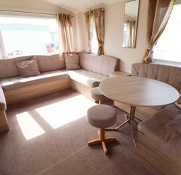A living room with a round table and sofa at The Seafront Cosy Caravan Ingoldmells