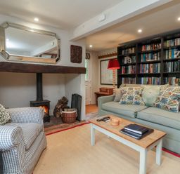 A living room with a sofa and armchair at The Bothy at Lewis Cottage in Spreyton