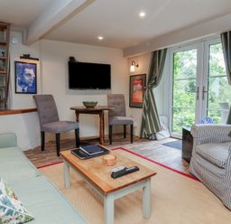 A living room with a sofa and chairs at The Bothy at Lewis Cottage in Spreyton