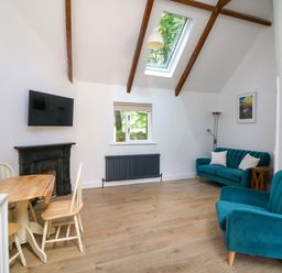 A living room with a sofa and dining table at The Mews @ Derrybawn in Laragh, County Wicklow
