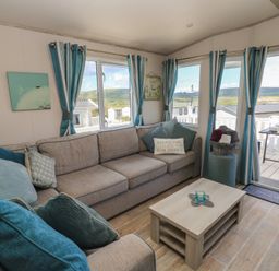 A living room with a sofa and coffee table at Swanny View in Swanage