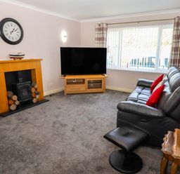 A living room with a television and sofa at Willow cottage in Seahouses