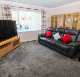 A living room with a television and a sofa at Willow cottage in Seahouses
