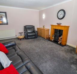 A living room with a sofa and armchair at Willow cottage Seahouses