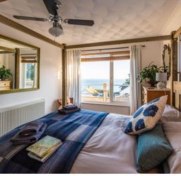 A bedroom with a bed and a window with a view at 1 Bed Flat - Sleeps 2 - Pets - Balcony - Parking in Looe