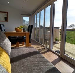 A dining area with a table and chairs at Cleeves Cabins 2, Arran Luxury Lodge with hot tub St. John's Town Of Dalry