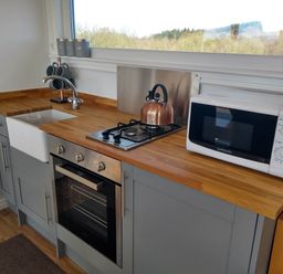 A kitchen with appliances and wooden counter at Cleeves Cabins 2, Arran Luxury Lodge with hot tub St. John's Town Of Dalry