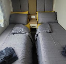 A bedroom with two beds and a bedside table at Beachside Lodge - Sleeps 6 - Pets ok - Parking Heysham