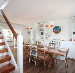 A dining room with a table and chairs at Lorrell in Salcombe
