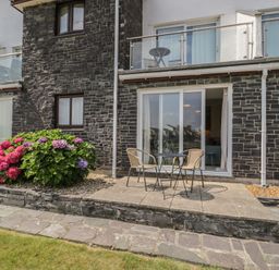 An outdoor area with a flower bed and a table with chairs at Harbourside in Porthmadog