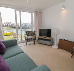A living room with a sofa and television at Harbourside in Porthmadog