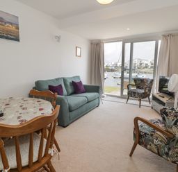 A living room with a sofa and dining table at Harbourside in Porthmadog