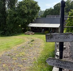 An outdoor area with signposts directing to reception and parking at Walnut Tree Lodge WITH hot tub Presteigne