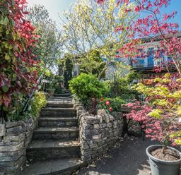 A garden with stone stairs and plants at 7 The Cedars in Wotton-Under-Edge