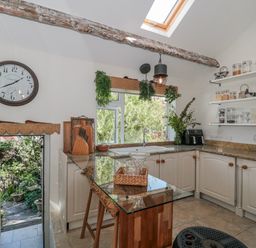 A kitchen with cabinets, sink, and shelving at 7 The Cedars in Wotton-Under-Edge