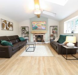 A living room with sofas and a fireplace at Bramley Cottage in Worlingham