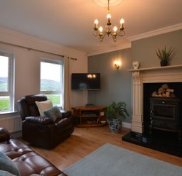 A living room with a television and fireplace at An Grianan Getaway in Burt