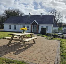 A house with a picnic table and flowers at An Grianan Getaway in Burt