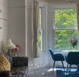 A living room with a sofa and a dining area at Apartment 6 Torquay