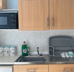 A kitchen with a sink and microwave at Apartment 6 in Torquay