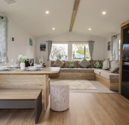 A living room with a dining area and couch at Shamrocks Cove Caravan