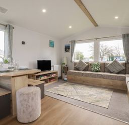 A living room with a dining table and sofa at Shamrocks Cove Caravan