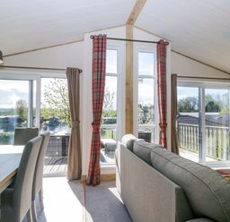 A living room with a sofa and dining area at Borwick Heights 17 in Carnforth