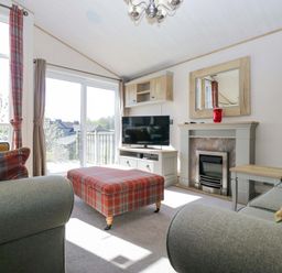 A living room with a television and a fireplace at Borwick Heights 17 in Carnforth