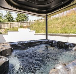 A hot tub with water in an outdoor area at Brynseion Uchaf near Aberystwyth