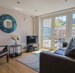 A living room with a sofa and television at Beck House in Weymouth