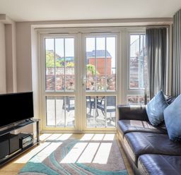 A living room with a TV and a sofa at Beck House in Weymouth