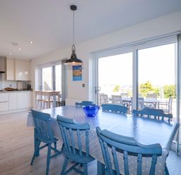 A kitchen with a dining table and chairs at Serfaus Perranporth