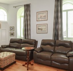 A living room with sofas and a side table at Farthings, The Old Chapel St. Austell
