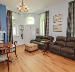 A living room with sofas and a table at Farthings, The Old Chapel St. Austell