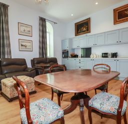 A living room with seating and kitchen area at Farthings, The Old Chapel, St. Austell