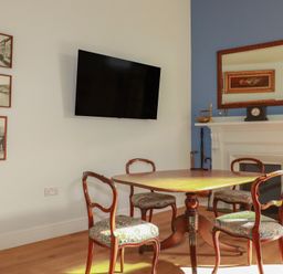 A dining room with a table and chairs at Farthings, The Old Chapel in St Austell