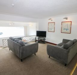 A living room with sofas and a television at Seaview in Y Felinheli