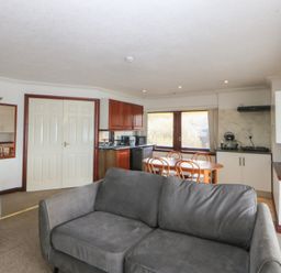 A living room with a sofa and dining area at Seaview in Y Felinheli